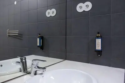 a bathroom with a white sink and a mirror at Batalha Mezzanine Penthouse in Porto