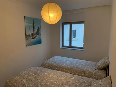 a room with two beds and a lamp and a window at City Heart Place 4 in Porto