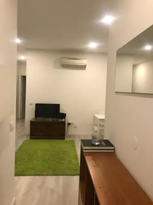 a living room with a green rug and a desk at City Heart Place 4 in Porto