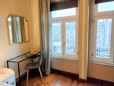 a room with a desk and windows with a view at Porto Main Square Penthouse Apartment in Porto