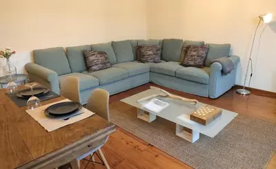 a living room with a blue couch and a table at Porto Main Square Penthouse Apartment in Porto