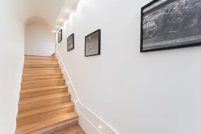 a hallway with white walls and wood floors and framed pictures at GuestReady - Porto D'Alma - Stª Catarina 1E in Porto