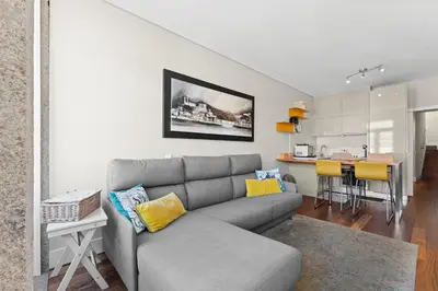 a living room with a couch and a kitchen at GuestReady - Cardosas Town Apartment in Porto