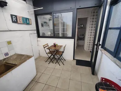 a small kitchen with a table and chairs in a room at Casa da Rita in Porto