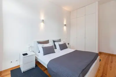 a bedroom with a large bed with white walls at BO - Bolhão Apartments in Porto