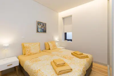 a bedroom with a bed with two towels on it at Luz & Alegria Place! in Porto