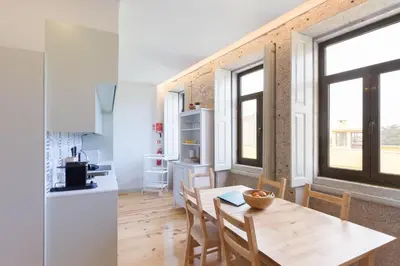 a kitchen and dining room with a table and chairs at Luz & Alegria Place! in Porto