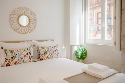 a bedroom with a bed with a mirror and a window at Porto City Cottage in Ribeira neighborhood in Porto