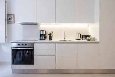 a white kitchen with a stove and a sink at Porto City Cottage in Ribeira neighborhood in Porto