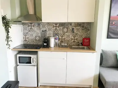 a small kitchen with white cabinets and a microwave at Little Tower in Porto