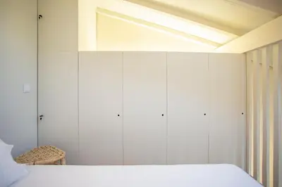 a bedroom with white wardrobes and a bed at Estúdio 22 na Boavista, JAMBA House in Porto