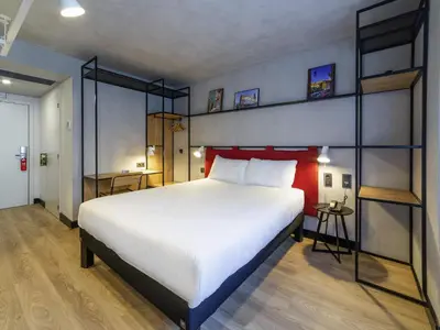 a living room with a couch and a book shelf at ibis Porto Centro Mercado Bolhao in Porto