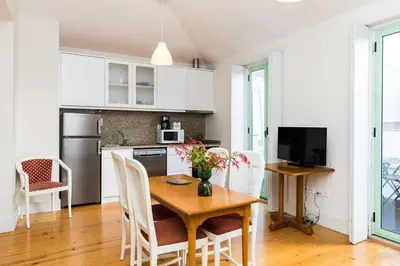 a kitchen and dining room with a wooden table and chairs at VIVA Ilda's Home in Porto