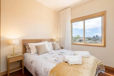 a bedroom with a large bed with a window at Host Wise - Anna Flats in Vila Nova de Gaia