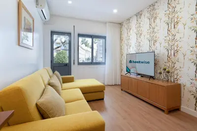a living room with a yellow couch and a tv at Host Wise - Anna Flats in Vila Nova de Gaia