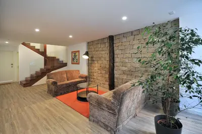 a living room with two chairs and a brick wall at FLH Oporto Wine Cellars Luxury Apartment II in Vila Nova de Gaia