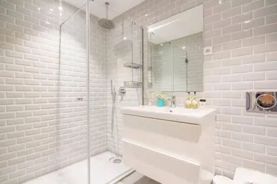 a white bathroom with a sink and a shower at Santa Catarina Roof Top in Porto