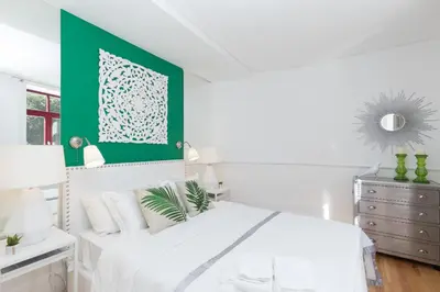 a bedroom with a white bed with a green wall at Loureiro Villas in Porto