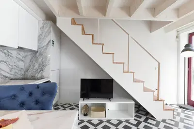 a living room with a staircase and a tv at Loureiro Villas in Porto