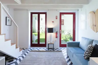 a living room with a blue couch and two windows at Loureiro Villas in Porto