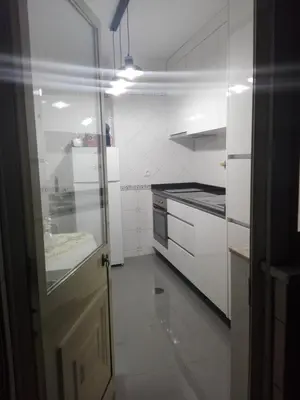a kitchen with white cabinets and a door and a sink at Secondlove in Porto