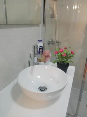 a white sink in a bathroom with pink flowers at Secondlove in Porto