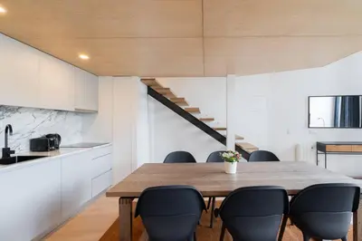 a kitchen and dining room with a wooden table and chairs at Loft Douro Cais da Fontaínha in Vila Nova de Gaia