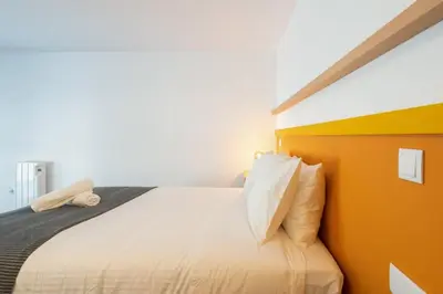 a bedroom with a large bed with orange walls at Loft Douro Cais da Fontaínha in Vila Nova de Gaia