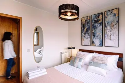 a woman walking into a bedroom with a bed at Porto bica velha - Carvalhido in Porto