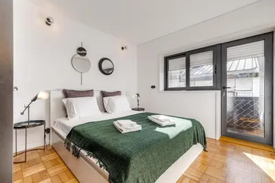 a white bedroom with a bed with a green blanket at Nomad's Family - 2BED Spacious Apartment Gaia in Vila Nova de Gaia