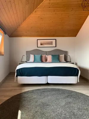 a bedroom with a large bed with a wooden ceiling at BF Suites & Apartments in Porto