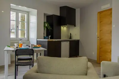 a kitchen and living room with a table and a chair at BF Suites & Apartments in Porto