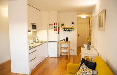 a living room with a yellow couch and a kitchen at Olival 54 Apartments in Porto