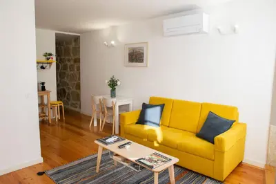 a living room with a yellow couch and a table at Olival 54 Apartments in Porto