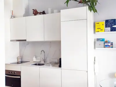 a kitchen with white cabinets and a sink at D858 - comfort near downtown - AC & balcony in Porto