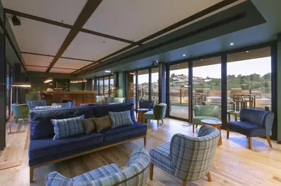 a living room with a blue couch and chairs at NEYA Porto Hotel in Porto