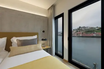 a bedroom with a bed and a large window at NEYA Porto Hotel in Porto