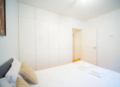 a white bedroom with a bed with white cabinets at Oporto City View - Alves da Veiga in Porto