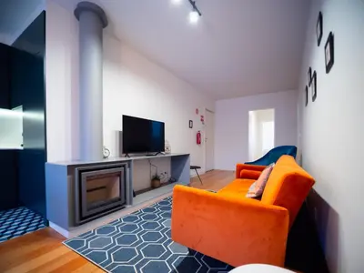 a living room with an orange couch and a fireplace at Oporto City View - Alves da Veiga in Porto