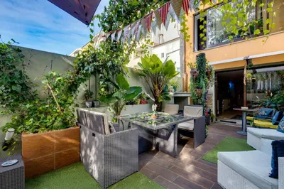 a patio with a table and chairs and plants at Garden in Town Hostel in Porto