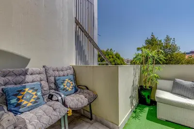 a balcony with chairs and pillows on a building at Garden in Town Hostel in Porto