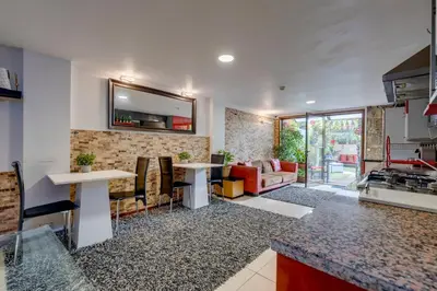 a kitchen and living room with a table and a couch at Garden in Town Hostel in Porto