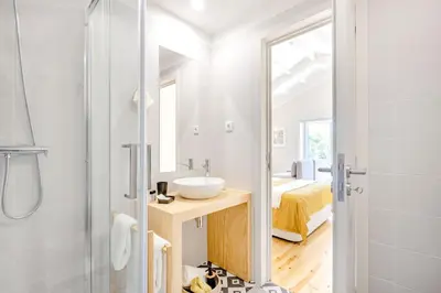 a hallway with white walls and a door with plants at Porto Downtown Studio w/ Balcony in Porto