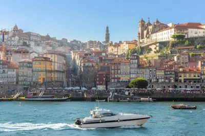 a boat in the water in front of a city at Porto Downtown Studio w/ Balcony in Porto