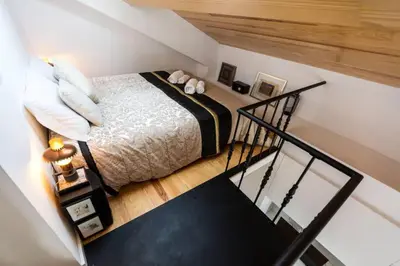 a small bedroom with a bed and a staircase at Oporto Down Town in Porto