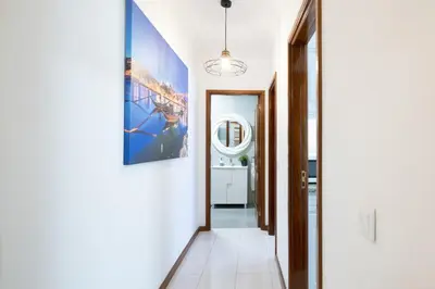 a hallway with white walls and a blue painting on the wall at GuestReady - Modern 2BR Flat in Vila Nova de Gaia in Porto