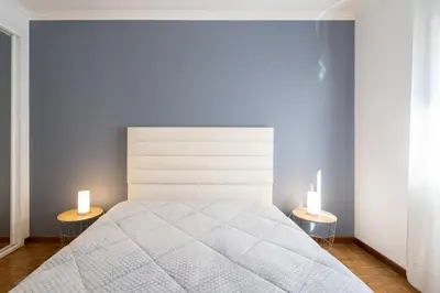 a bedroom with a bed and two candles on two tables at GuestReady - Modern 2BR Flat in Vila Nova de Gaia in Porto