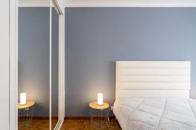 a bedroom with a bed and two tables with candles at GuestReady - Modern 2BR Flat in Vila Nova de Gaia in Porto