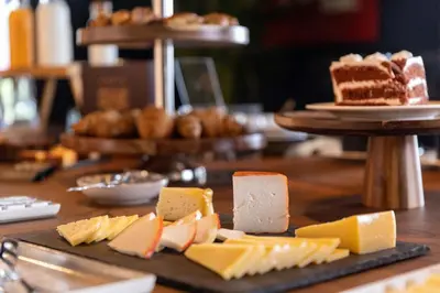 a table topped with different types of cheeses and cake at chic&basic Gravity in Porto