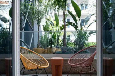 two chairs and a table in a room with plants at chic&basic Gravity in Porto